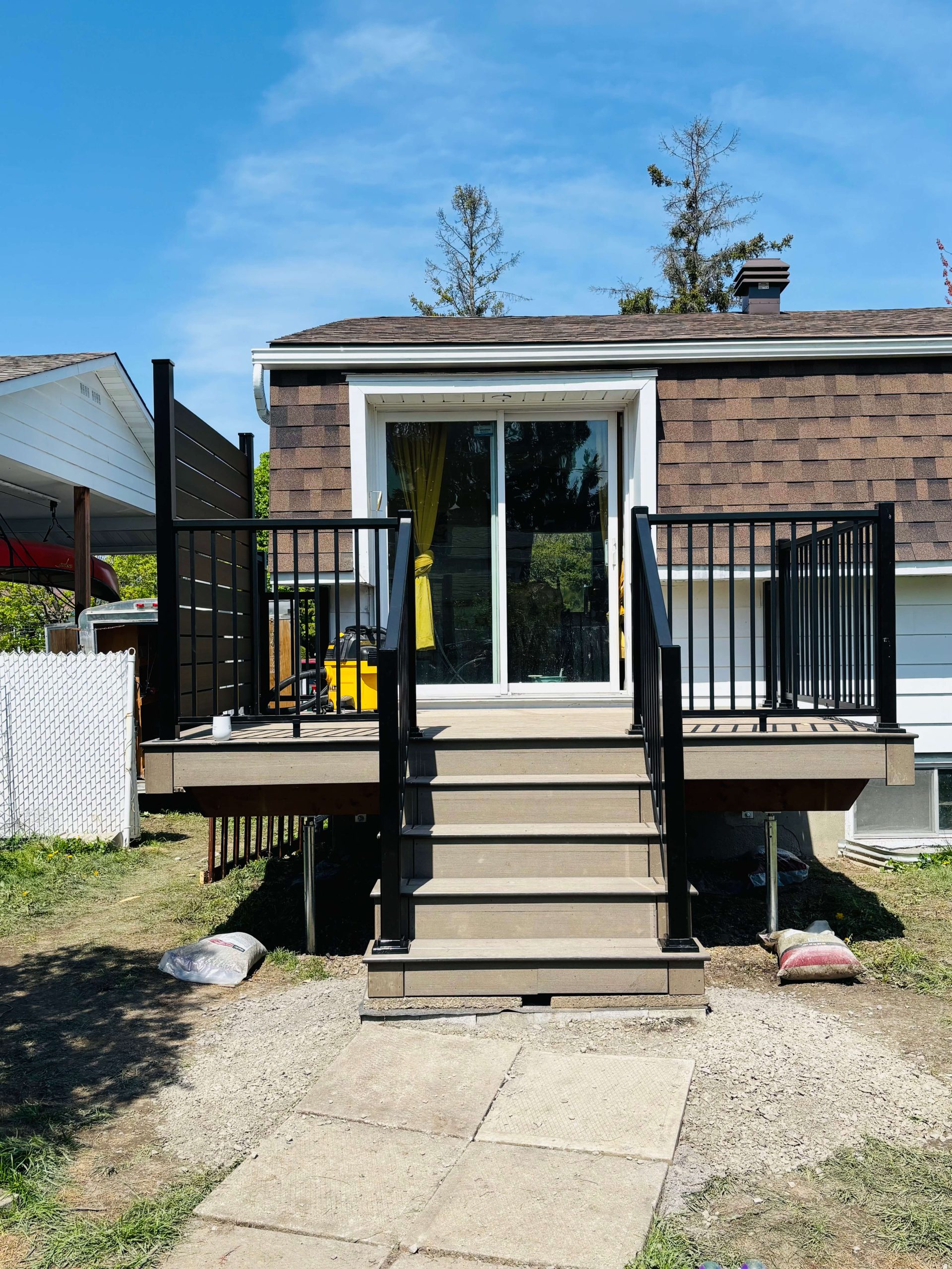 alt="Aménagement de patio en composite Ecoplast avec système de rampes sécuritaire et moderne"