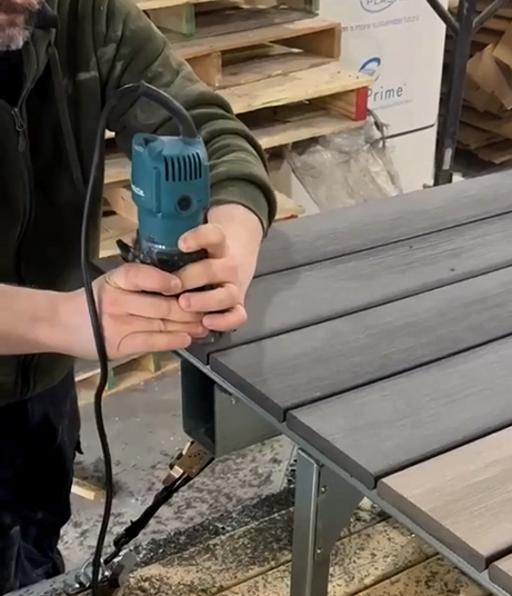 Ouvrier utilisant une toupie sur planche de composite plastique Écoplast