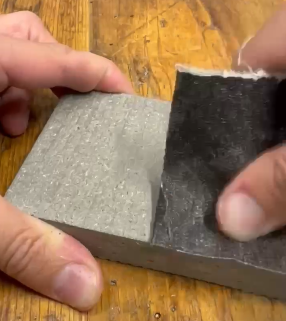 Démonstration de brossage pour l'entretien bois composite avec réparation d'une égratignure sur une planche de bois composite Écoplast sans membrane.