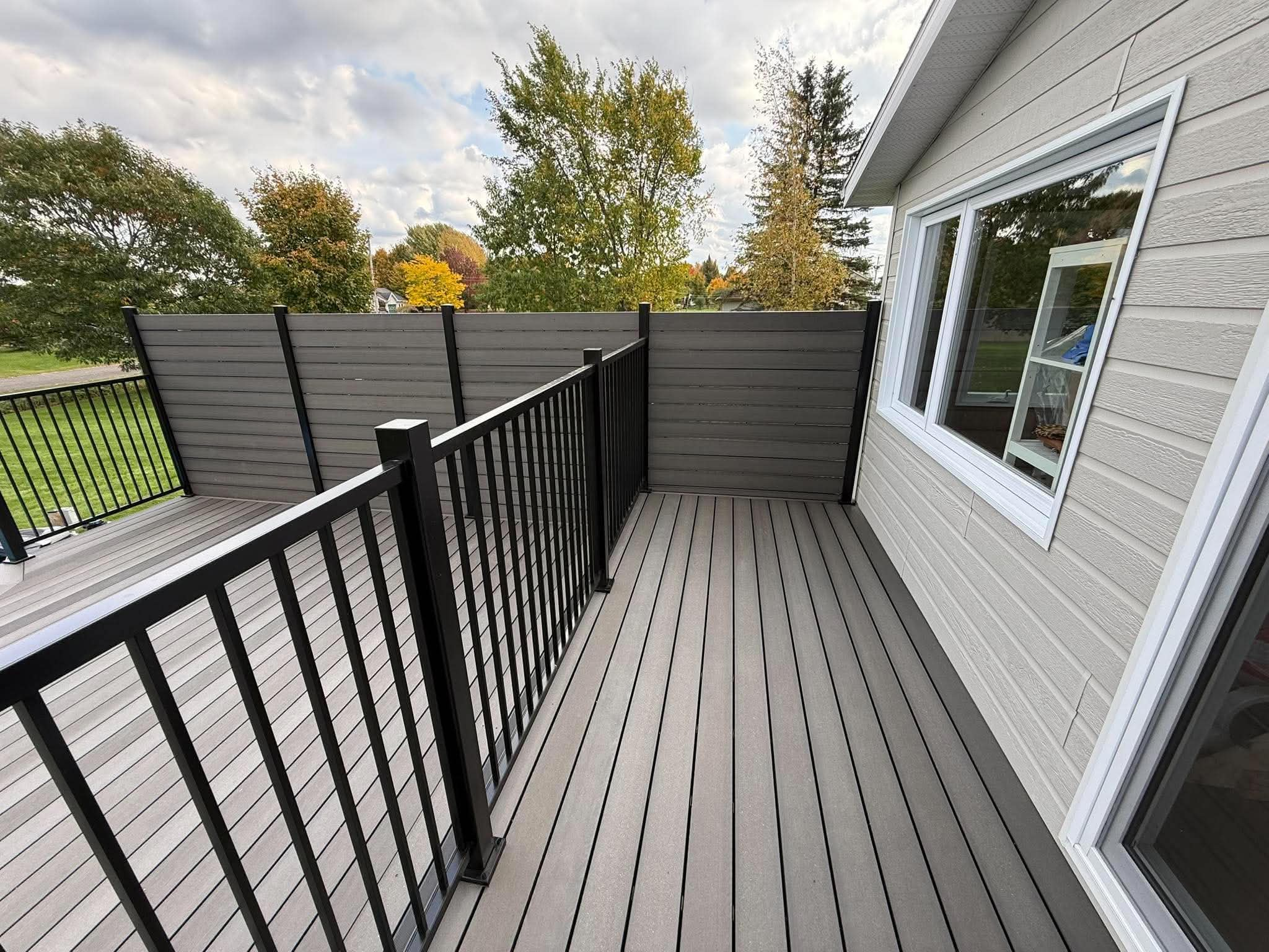 Patio en composite Écoplast couleur Onyx avec rampe et mur d'intimité en Beauce